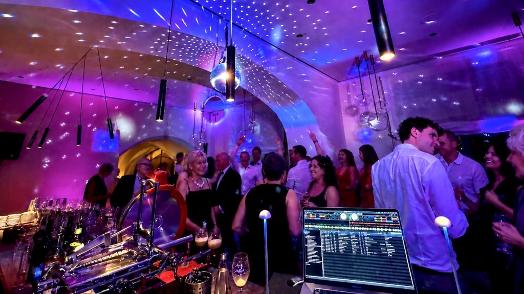 Geburtstagsfeier in der Bar des Bayerischen Nationalmuseums in München mit tanzenden Gästen, violetter Lichtshow und professioneller DJ-Technik von Best Time DJs.