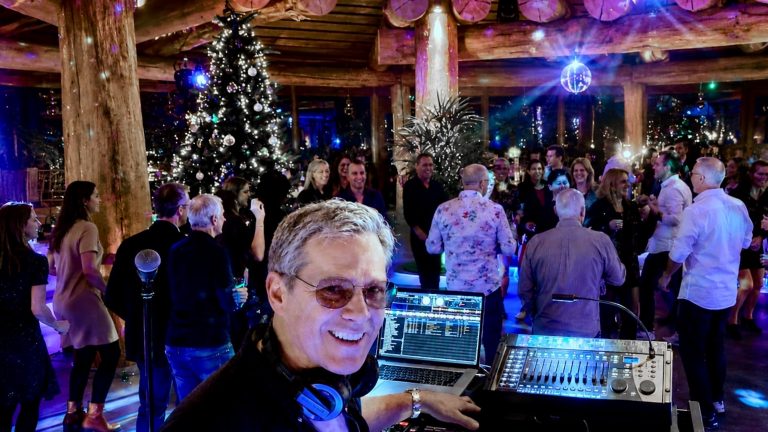 DJ Andreas von Best Time DJs an der DJ-Konsole vor einer tanzenden Gesellschaft zu einer Firmen-Weihnachtsfeier in der Therme Erding.