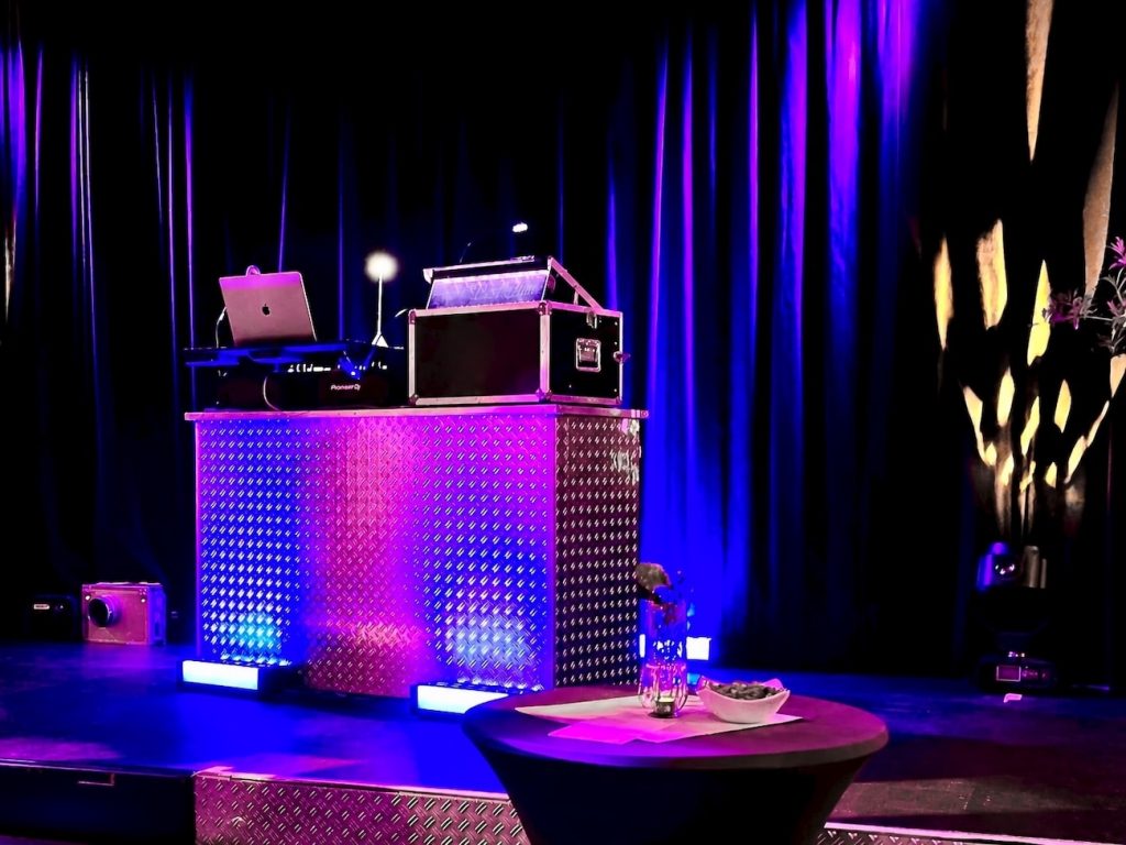 Professioneller DJ-Tisch mit Laptop und DJ-Controller, beleuchtet in Blau und Violett bei einem 50. Geburtstag von Best Time DJs in München.